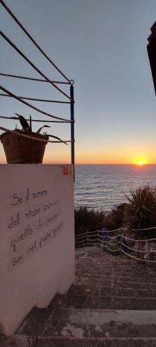 a sign on a wall with the sunset in the background at VILLE GIRASOLI "VILLA NELLA BAIA" with PRIVATE SWIMMING POOL in Tricase