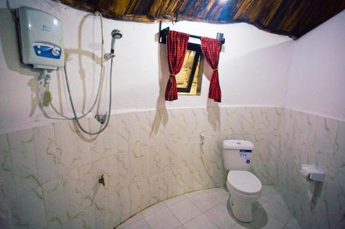 a small bathroom with a toilet and a window at Charming Eco-Homestay near Kilimanjaro International Airport in Arusha