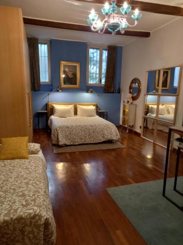 a bedroom with two beds and a blue wall at With FREE secure Parking garage , Montenapoleone Junior Suites - All comforts - The Best Unic location in town - Luxury Shopping & Leisure & Business district all by walk - Subway S-Babila M1 M4 Palestro M1 in Milan