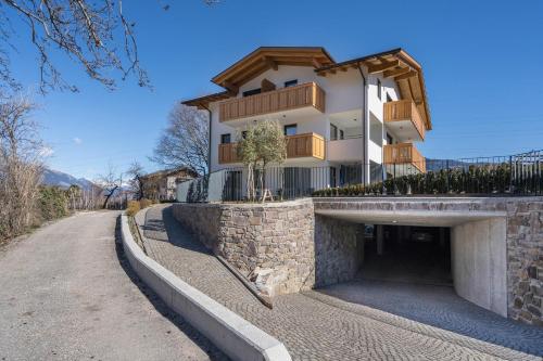 a building on top of a stone wall next to a road at Sunnig Apartment Abendsonne in Vollan