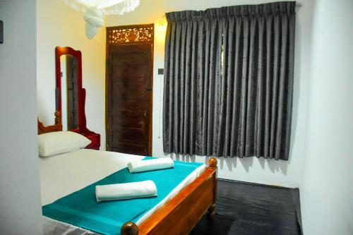 1 dormitorio con 1 cama con 2 toallas en Relax Guest House Dambulla en Dambulla