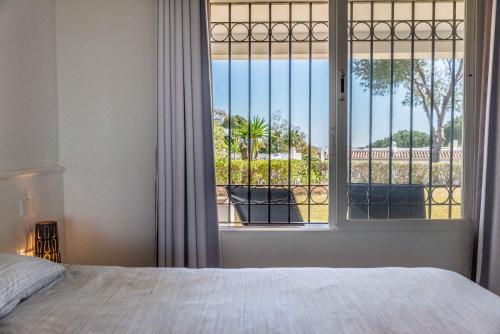 sypialnia z łóżkiem i oknem z widokiem w obiekcie 2bed apartment in Miraflores w mieście Mijas