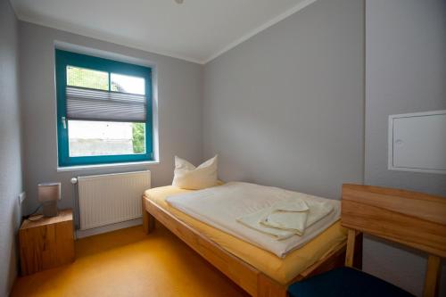Habitación pequeña con cama y ventana en Ferienwohnung A Gästehaus Mühlenstein, en Bad Sülze