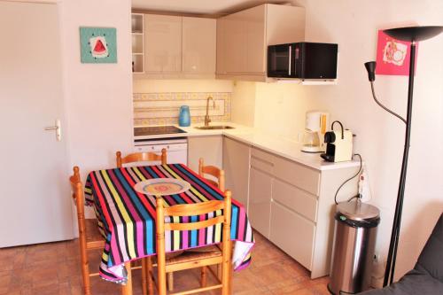 - une cuisine avec une table, une petite table et des chaises dans l'établissement Marine du Roussillon 123, à Saint-Cyprien