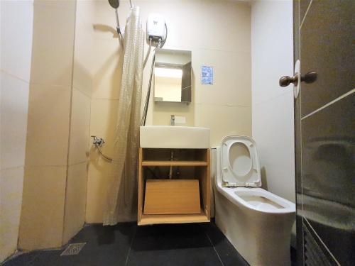 Spiral Suites Hotel في مانيلا: حمام مع حوض ومرحاض ودش