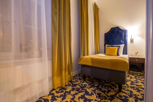 a bedroom with a bed with a blue headboard and yellow curtains at Hotel Gamla Stan, BW Signature Collection in Stockholm