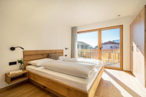 a bedroom with a large bed and a large window at Sunnig Apartment Sonnenschein in Vollan