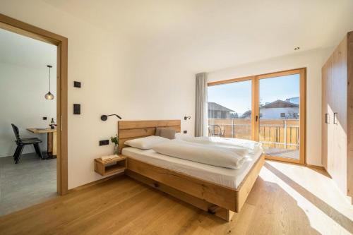 een slaapkamer met een groot bed en een groot raam bij Sunnig Apartment Sonnenschein in Vollan