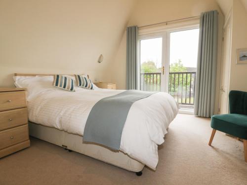 a bedroom with a bed and a large window at Lodge 22, Bodmin Holiday Park, Cornwall in Lanivet