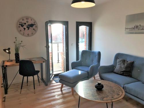 een woonkamer met twee blauwe stoelen en een tafel bij Speicher Residenz Barth E4 App 10 in Barth