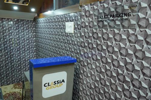 a wall with a trash can in front of a wall with a tile pattern at Classia Suites in Bengaluru