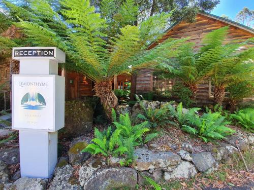 a sign in front of a house with plants at Lemonthyme Wilderness Retreat in Moina