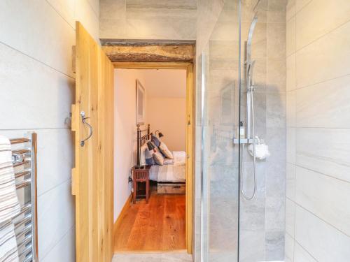 a bathroom with a shower with a glass door at Ty Gwyn Cottage in Llysfaen