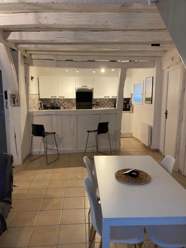 cocina y comedor con mesa y sillas en Le Marais Vous - Duplex en centre-ville., en Provins