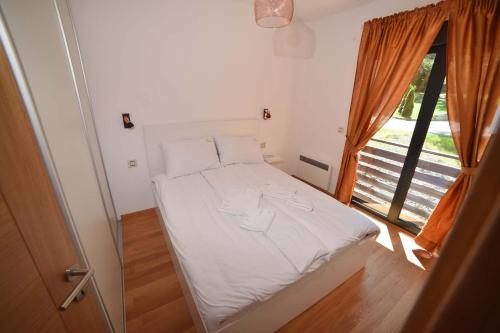 a white bed in a room with a window at Balkan Hill Zlatibor in Zlatibor