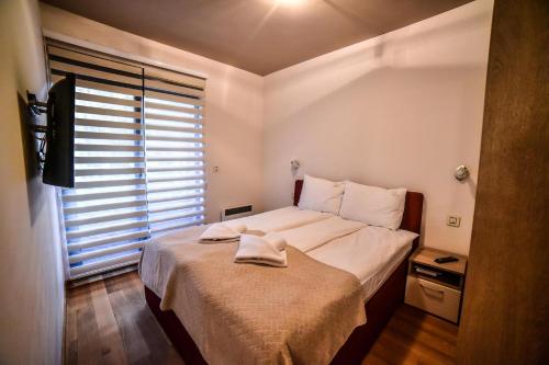 a bedroom with a large bed with a window at Balkan Hill Zlatibor in Zlatibor