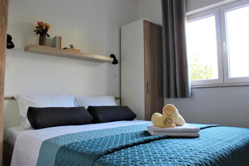 a bedroom with a bed with a teddy bear on it at Apartments Piscina-Green in Podstrana