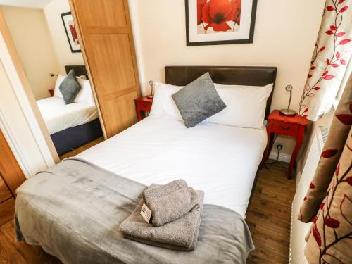 a small bedroom with a bed and a mirror at Primrose Lodge in Saltburn-by-the-Sea