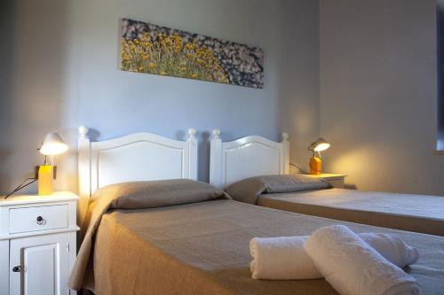 a bedroom with two beds and a painting on the wall at Ville dell'Eden con 9 camere da letto in 6 unità abitative in Lascari