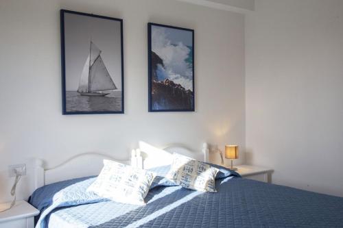 a bedroom with a bed with a sailboat on it at Ville dell'Eden con 9 camere da letto in 6 unità abitative in Lascari