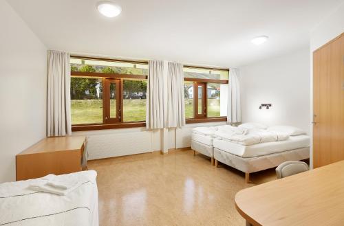 a living room with two beds and a table at Hótel Torfnes in Ísafjörður