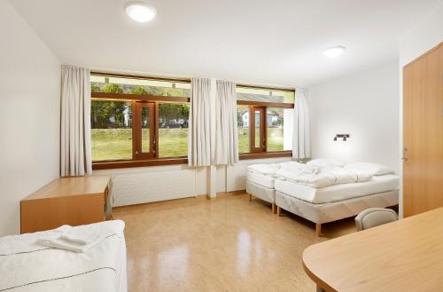 ein Wohnzimmer mit 2 Betten und einem Tisch in der Unterkunft Hótel Torfnes in Ísafjörður