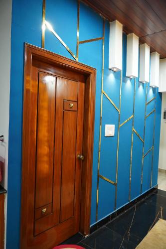 a wooden door in a room with a blue wall at Classia Suites in Bengaluru