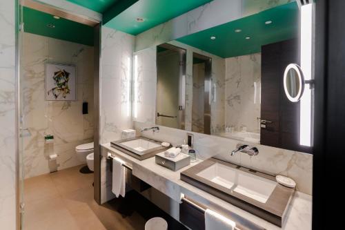a bathroom with two sinks and a large mirror at Hyatt Centric Jumeirah Dubai in Dubai