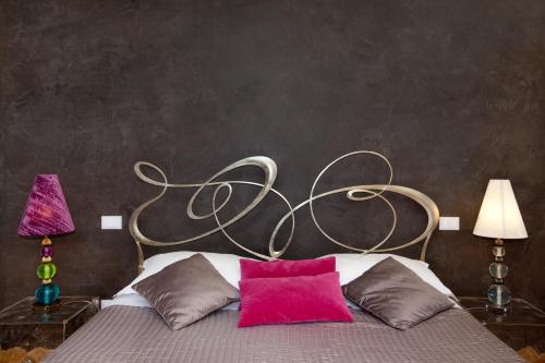 a bedroom with a bed with pink and brown pillows at Town House Fontana Di Trevi in Rome