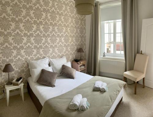 a bedroom with two towels on a bed at Hotel Le Normand in Houlgate