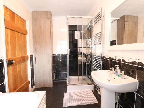 a bathroom with a sink and a glass shower at Duck Cottage in Snettisham