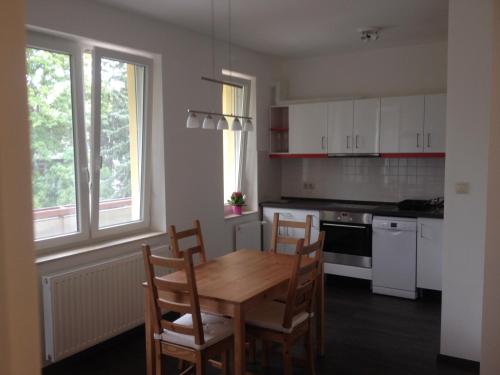 una cocina con mesa de madera y sillas. en Platán apartman en Budapest