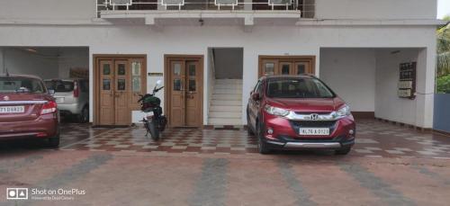 a red car parked in front of a building at Wintervalley homestay in Vayittiri