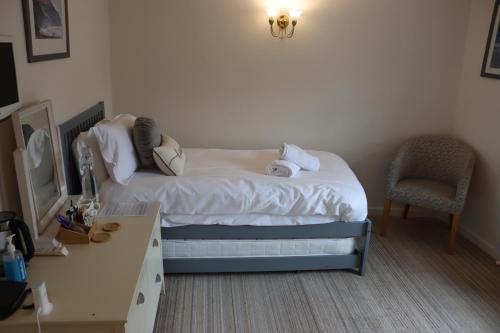 a small bedroom with a bed and a desk at The Mariners Hotel in Lyme Regis