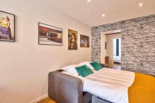 une chambre avec un lit et un mur de briques dans l'établissement 04 Best Flat Montorgeuil 3, à Paris