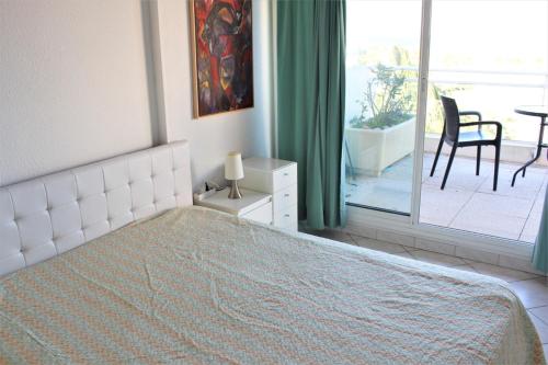 - une chambre blanche avec un lit et un balcon dans l'établissement GOELETTES 311, à Saint-Cyprien
