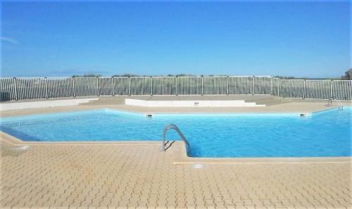 une grande piscine entourée d'une clôture. dans l'établissement GOELETTES 311, à Saint-Cyprien