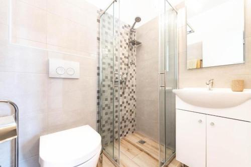 a bathroom with a shower and a toilet and a sink at Apartments Niko in Novalja