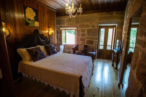 um quarto com uma cama num quarto com paredes de madeira em Casas da Fraga 2020 em Ribeira de Pena