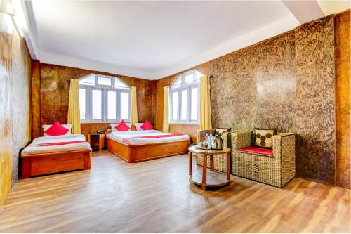 a room with two beds and a table and chairs at Yul Pemakhar in Tawang