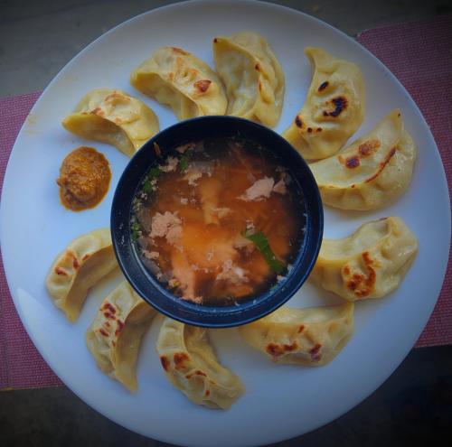 a plate of wontons with a bowl of soup at The Silver Spring Homestay in Darjeeling