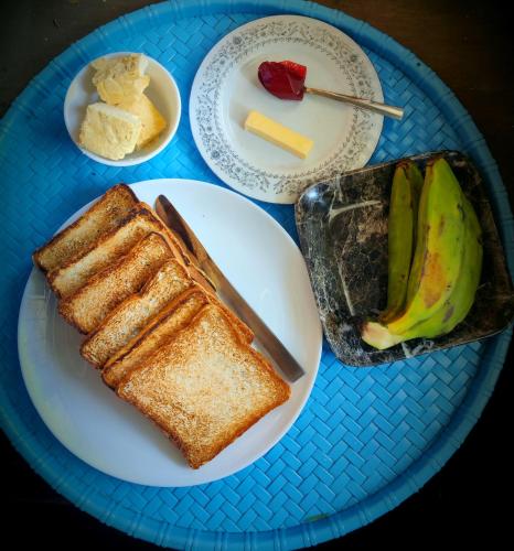 a blue plate with toast and bananas on a table at The Silver Spring Homestay in Darjeeling