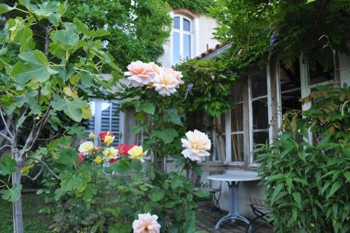 a table in front of a house with flowers at Moulin de Merzé in Cortambert