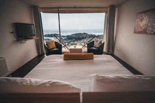 um quarto com uma cama e vista para o oceano em Hotel 8 al Mar em Pichilemu