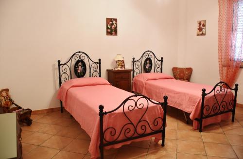 a bedroom with two beds with red covers and a tiled floor at Appartamento Girasole in Santa Domenica