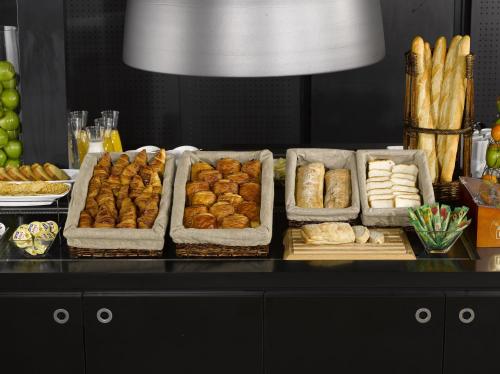 ein Buffet mit vielen Tabletts Gebäck und Brot in der Unterkunft Campanile Metz Est Technopole - Restaurant in Metz