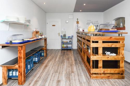 a kitchen with a counter and wooden floors at Hotel-Pension Janssen - Gästehaus Huus an't Deep in Neuharlingersiel