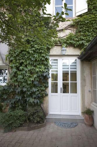 a white door on the side of a building at Moulin de Merzé in Cortambert