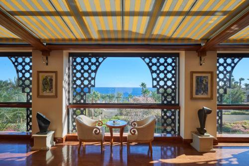 a living room with a table and chairs and large windows at Four Seasons Resort Sharm El Sheikh in Sharm El Sheikh