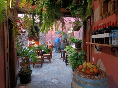 un restaurante con mesa, sillas y plantas en Rural Suite Santiago de Tunte, en San Bartolomé